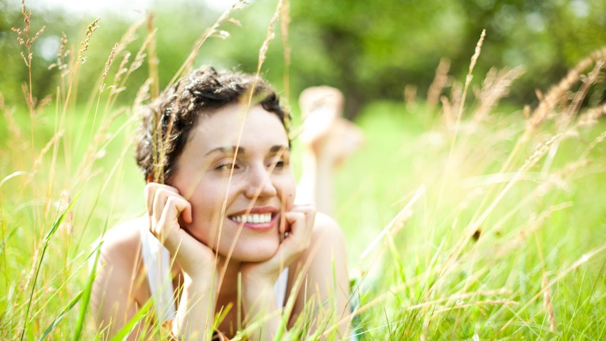 A woman laying in a field of tall grass